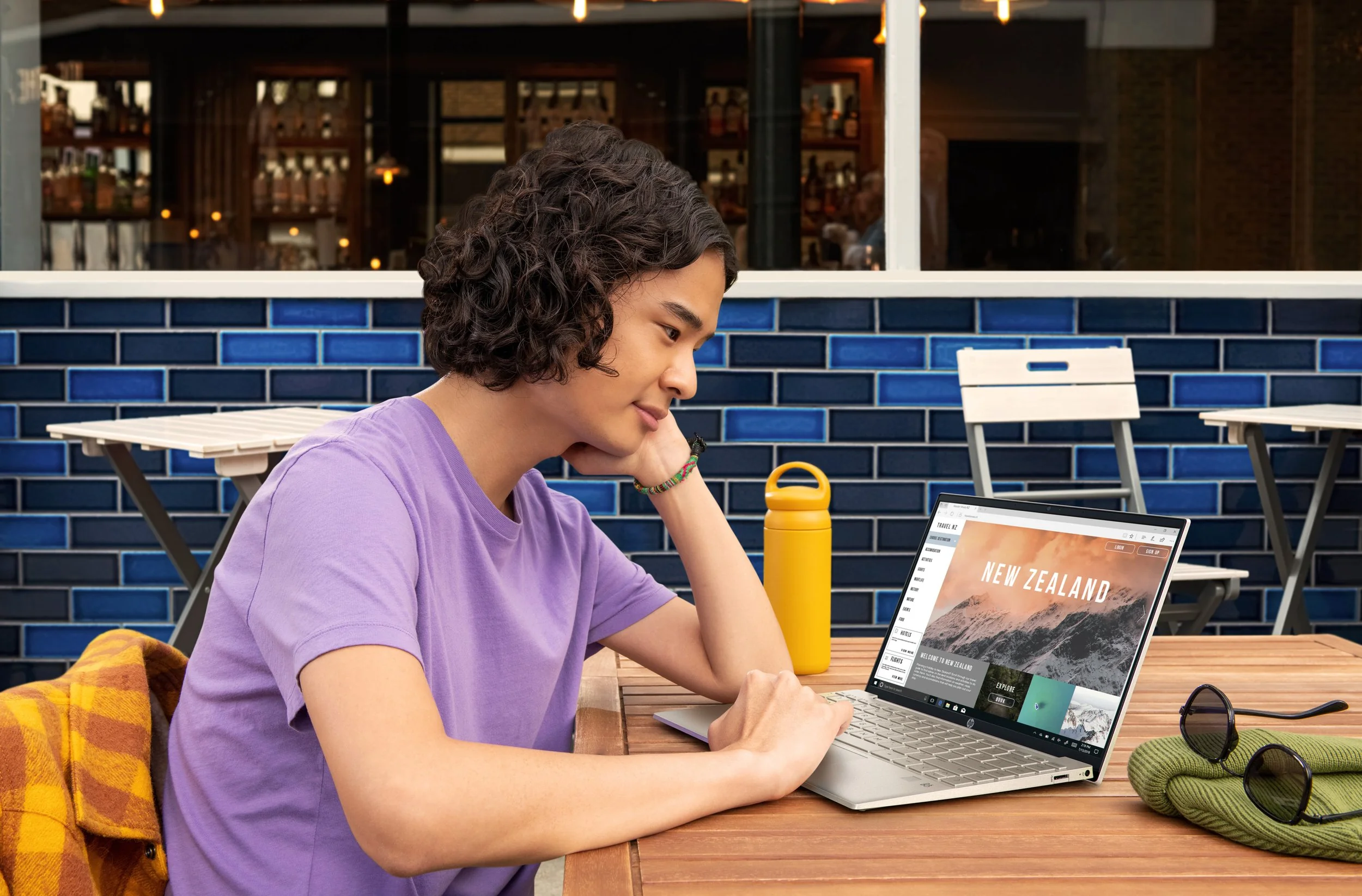 Woman using a silver laptop at a café table