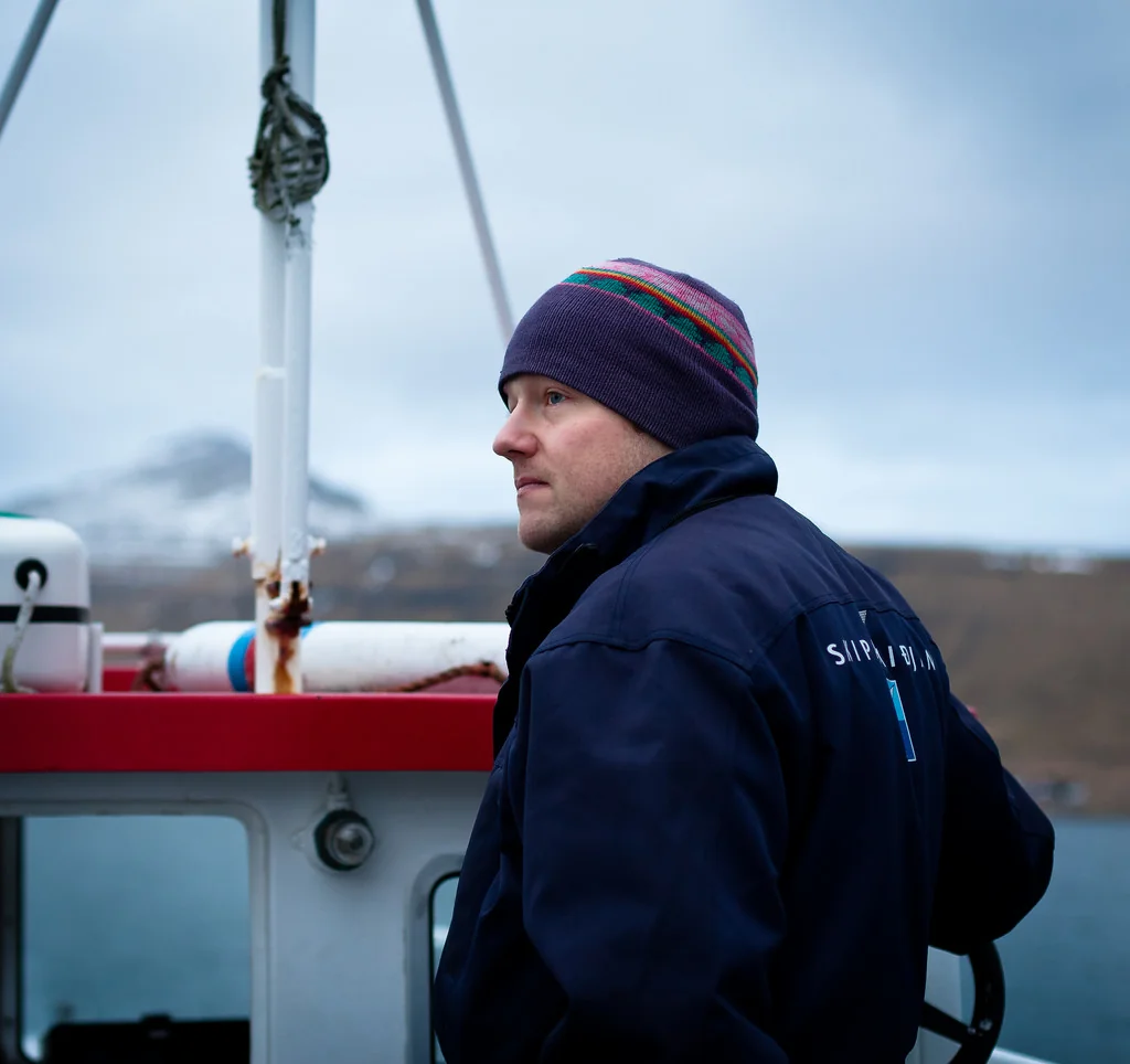 Man in a knit cap standing on a boat
