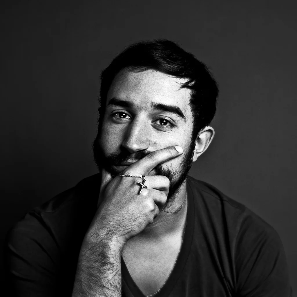 Black-and-white portrait of a man resting his hand on his chin
