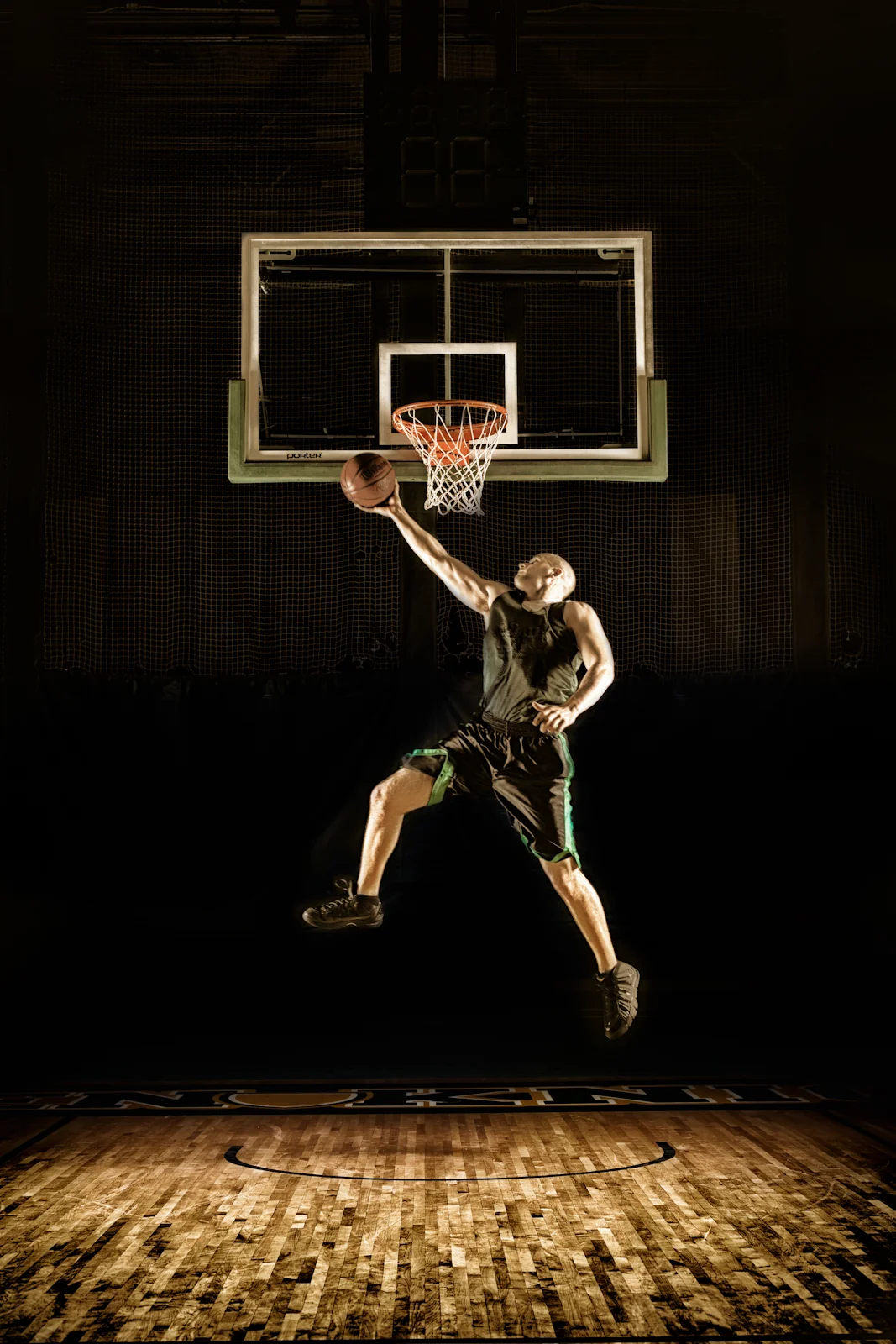 Basketball player suspended beneath the hoop for a dunk